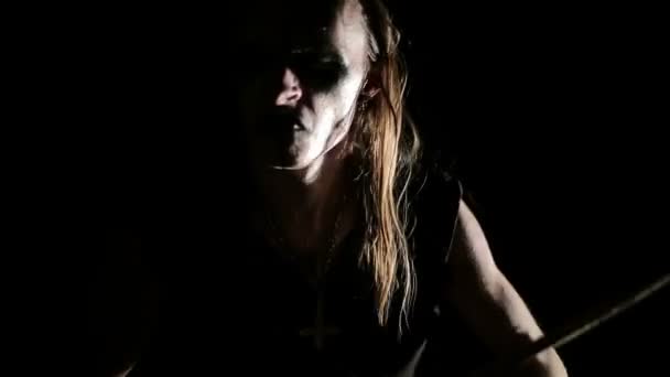 Барабанщик блэк-метал группы. Закрыть лицо на темном фоне — стоковое видео