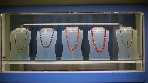 Contas de âmbar e pulseiras em uma janela da demonstração da loja de jóias — Vídeo de Stock