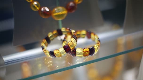 Amber parels en armbanden op een Toon-venster van shop van sieraden — Stockvideo