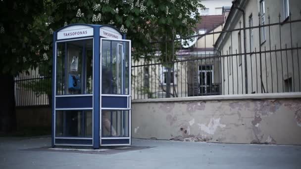 Ночная Восточная Европа. Молодой человек звонит по таксофону — стоковое видео
