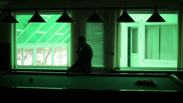 Man talking on the phone in the dark billiard room — Stock Video