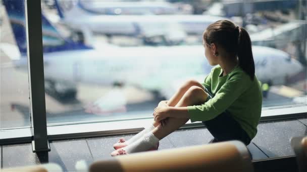 Bambino all'aeroporto vicino alla finestra guardando gli aerei e aspettando il tempo di volo — Video Stock