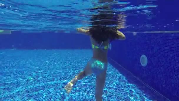 Дитина стрибає в басейн і плаває під водою — стокове відео