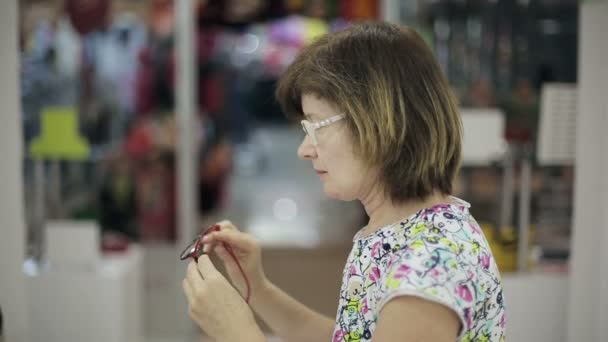 Senior woman chooses new glasses — Stock Video