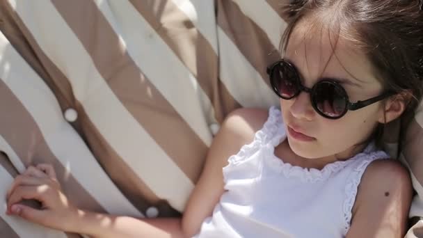 Flickebarn koppla av utomhus i en hängmatta — Stockvideo