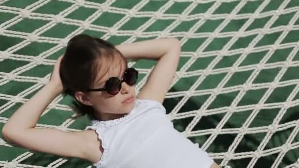 Жіноча дитина розслабляється на відкритому повітрі в гамаку — стокове відео