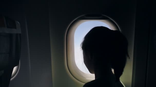 Niño mirando fuera de la ventana del avión — Vídeos de Stock