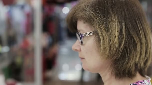 Kadın kıdemli yeni gözlük seçer. Yakın çekim — Stok video