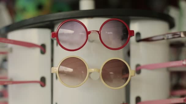 Барвисті сонцезахисні окуляри для дітей на продаж на міському ринку — стокове відео