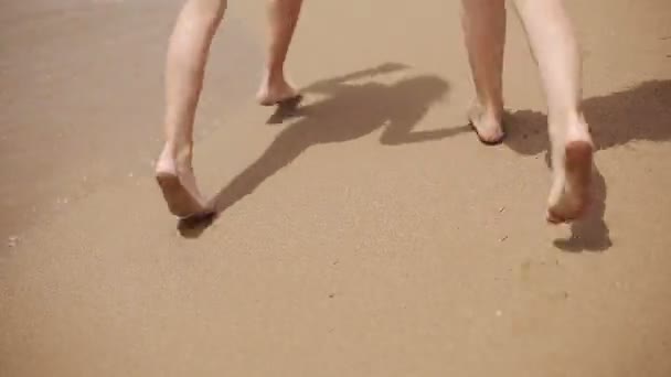 Enfants courant sur la plage le long de la mer — Video