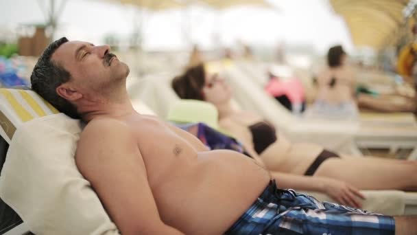 Pareja mayor tomando el sol en la playa — Vídeos de Stock