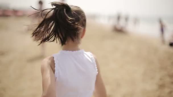 Niño feliz corriendo por la playa y a veces mira hacia atrás — Vídeos de Stock