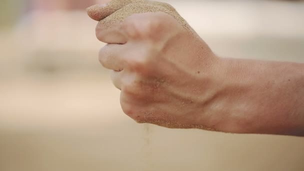 Женщина с песком, падающим через ее руки на пляже. Закрыть — стоковое видео