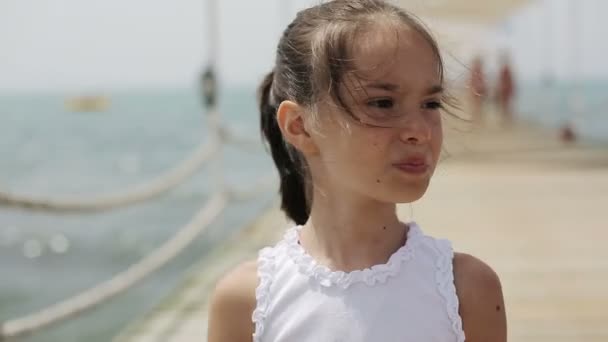 Niño caminando en un muelle de madera cerca del mar — Vídeos de Stock