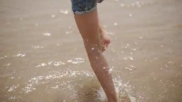 Anak yang bahagia berjalan di sepanjang pantai. Gerakan lambat — Stok Video