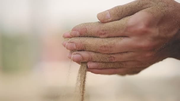 Donna con la sabbia che cade tra le mani sulla spiaggia. Da vicino. — Video Stock