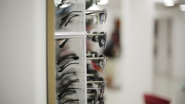 Gafas mostradas en una pared en la tienda óptica — Vídeos de Stock