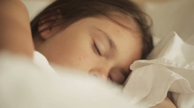 Sevimli küçük kız yatakta uyuyor. Yakın çekim
