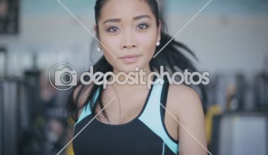 Spor salonunda treadmill çalıştıran çekici Asyalı kız. Tam yüz portre. Yakın çekim