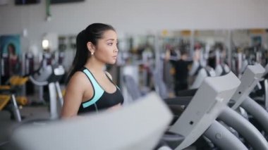 Spor salonunda treadmill çalıştıran çekici Asyalı kız. Doğru profil yüz