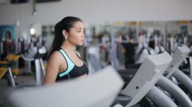 Spor salonunda treadmill çalıştıran çekici Asyalı kız. Doğru profil yüz