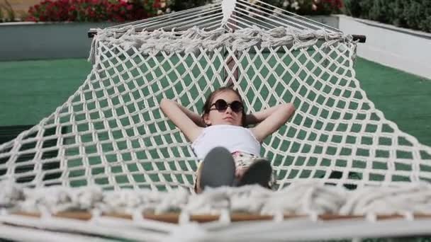 Female child relaxing outdoors in a hammock — Stock Video