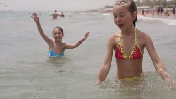 Kinderen zwemt in de zee springen op de golven — Stockvideo