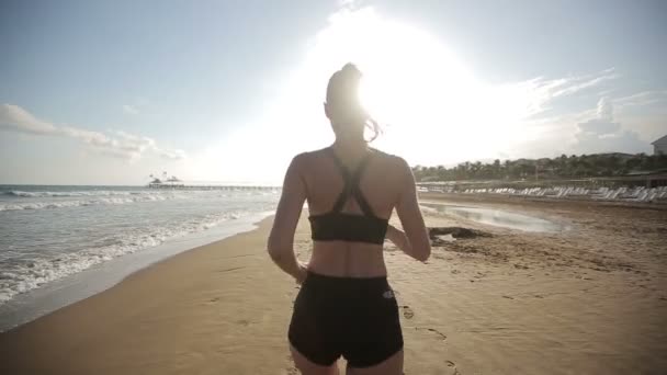 Vrouw draait alleen op de prachtige zonsondergang op het strand — Stockvideo