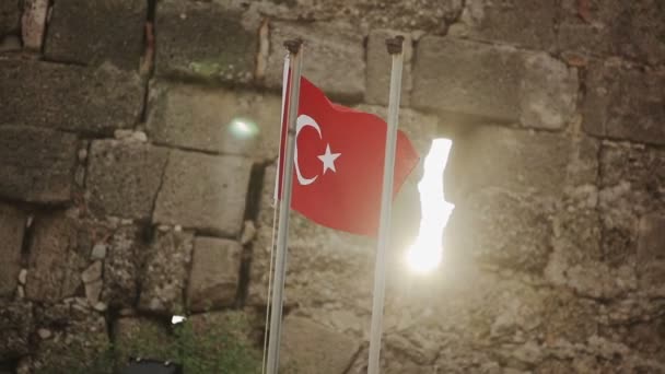 Török zászló egy kőfal háttérben a naplemente — Stock videók