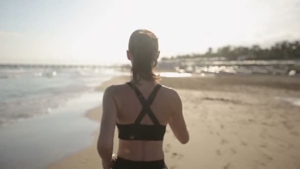 Vrouw draait alleen op de prachtige zonsondergang op het strand — Stockvideo