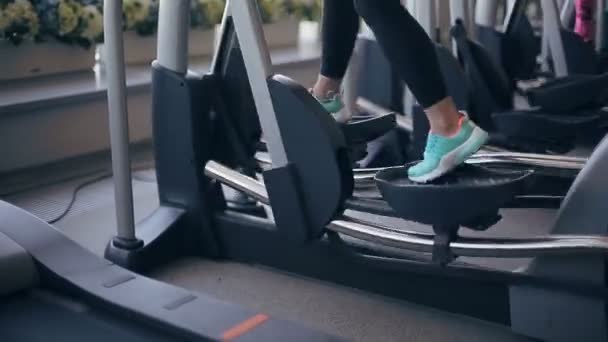 Mujer en el gimnasio haciendo ejercicio en la máquina xtrainer — Vídeos de Stock