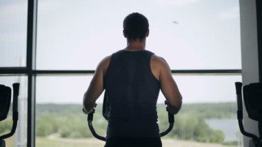Süzgeç makinede egzersiz spor salonunda yakışıklı adam silüeti. Orta atış