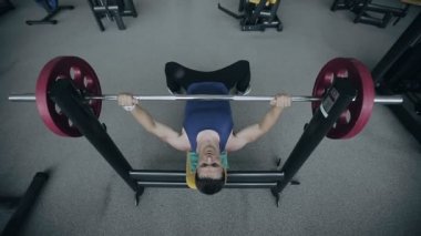 Kaslı adam ağırlık kaldırıyor. Geniş-açı mercek vurdu