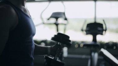 Adam vücut geliştirmeci spor salonunda egzersiz dumbbells ile yürütmek. Yüzü olmayan