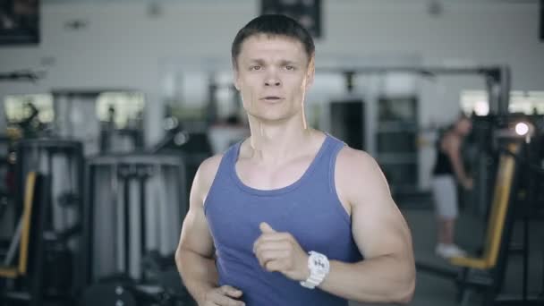 Man kör på löpbandet på gymmet. Full face porträtt — Stockvideo