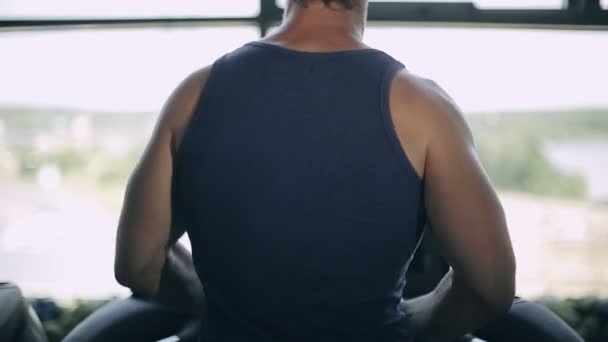 Σιλουέτα του ανθρώπου τρέχοντας treadmill και εξετάζει το μεγάλο παράθυρο — Αρχείο Βίντεο