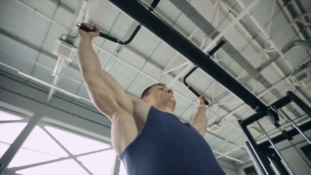 Närbild på manliga kroppsbyggare dra upp i ett gym. Slow motion — Stockvideo