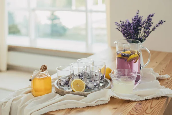Fresh lavender lemonade, lemons, honey, lemon juice and glasses on a kitchen table. Healthy food and drink.