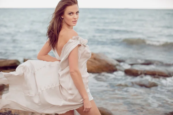 Piękna Dziewczyna Sukience Światła Kamienistym Brzegu Morza Cieszą Się Wiatr — Zdjęcie stockowe