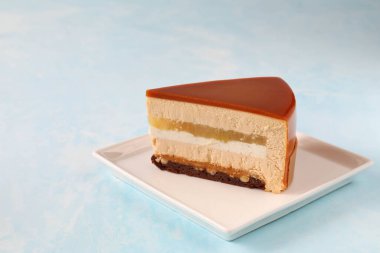 Masadaki bir tabakta tek bir parça kremalı pasta.