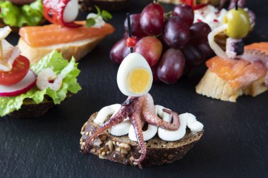 Geleneksel İspanyol mezeleri - ahtapot sandviçi, krem peynir ve bıldırcın yumurtası