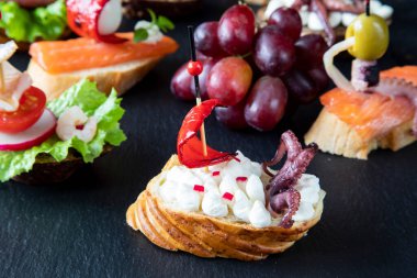 Krem peynir, turp, kırmızı biber ve dokunaçlı ahtapottan oluşan yelkenli bir tekneye benzeyen yaratıcı İspanyol sandviçi.