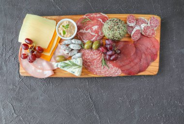 İtalyan bölgesinden şarap, sosis, peynir, ekmek, taze sebze, yeşil otlar ve üzümlerle dolu et panosu - üst görünüm ve kopyalama alanı