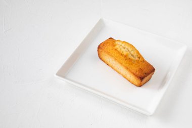 Beyaz bir masada beyaz bir tabakta tek bir Fransız pastası - geleneksel finansör pastası