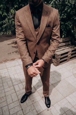 Koyu tenli bir adamın takım elbisesi, smokin, üç parçalı takım elbise.