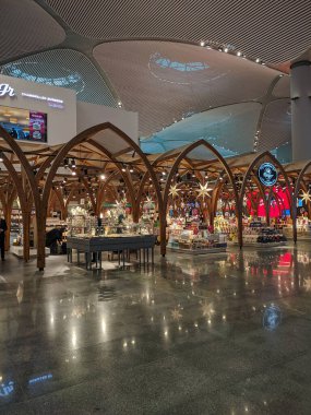 İstanbul, Türkiye - 12 Aralık 2019: İstanbul 'un ana havaalanı IST' si Yeni Yıl oyuncaklarıyla süslendi. Büyük salonda, insanlar havaalanında yürür. Dikey.