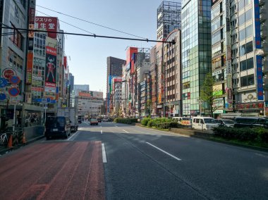 TOKYO, JAPONYA - 3 Nisan 2018: Shinjuku Caddesi, Tokyo 'da trafik. Büyük, yüksek binalar, ünlü markalar, arabalar birbirine yakın gidiyor..