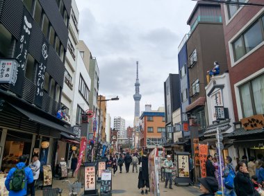TOKYO, JAPONYA - 3 Nisan 2018: Asakusa bölgesinde bir sokakta, Tokyo Skytree TV kulesi uzaktan görülebilir. Sokakta bir sürü kafe ve dükkan var..