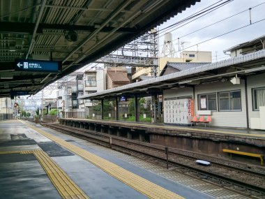 KYOTO, JAPAN - APRIL 5, 2018: Railway platform for waiting trains in Kyoto, Japan. There are houses in the national Japanese style near the station.