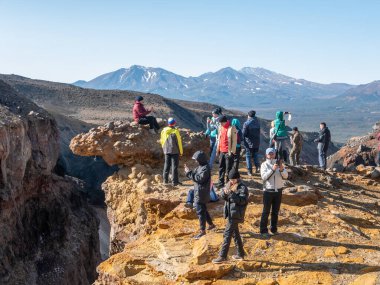 Mutnovsky yanardağının yakınındaki Opasny Kanyonu manzarası. Turistler kanyonun kenarında durur ve volkanların inanılmaz manzarasına hayran kalırlar. Kamçatka Yarımadası, Rusya.